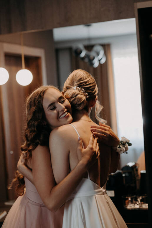 Fotografia ślubna Kraków, piekny moment, pani młoda przytula się z przyjaciółką przed swoim ślubem