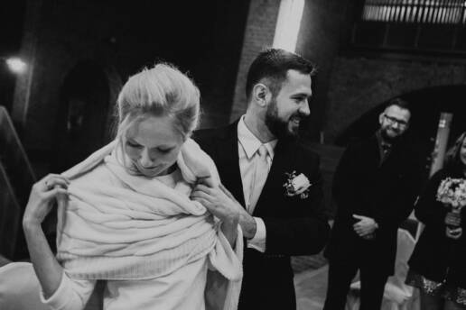Pan Młody otula panią młodą szalikiem, zimowy ślub w Gliwicach